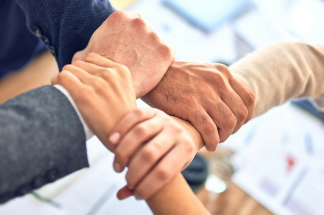 team-members-gripping-wrists-in-unity-gesture.jpg team members gripping wrists in unity gesture